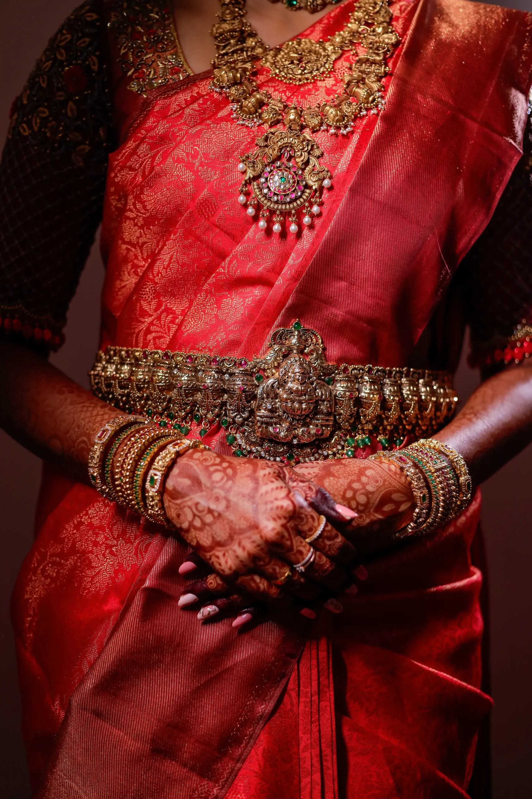 Close-up shot of an Indian bride's hands adorned with heavy gold bangles, red henna, and traditional jewelry.🏢 Yuvi Studio Fotography & Film Making 📷 Best Wedding Photographers 📍 Velayuthampalayam, Karur