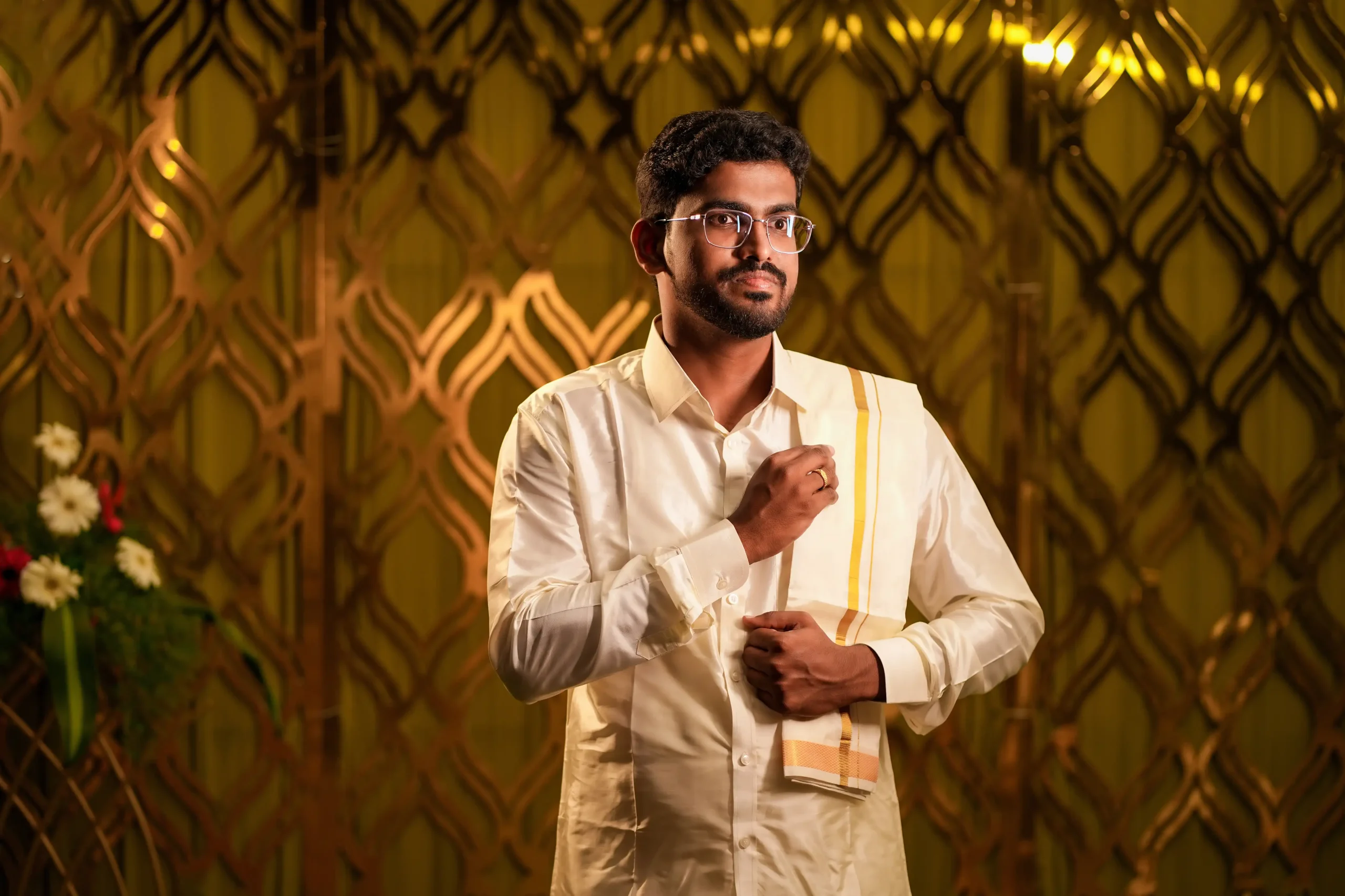 Young man in traditional South Indian clothing adjusting his shirt 🏢 Yuvi Studio Fotography & Film Making 📷 Best Wedding Photographers 📍 Velayuthampalayam, Karur
