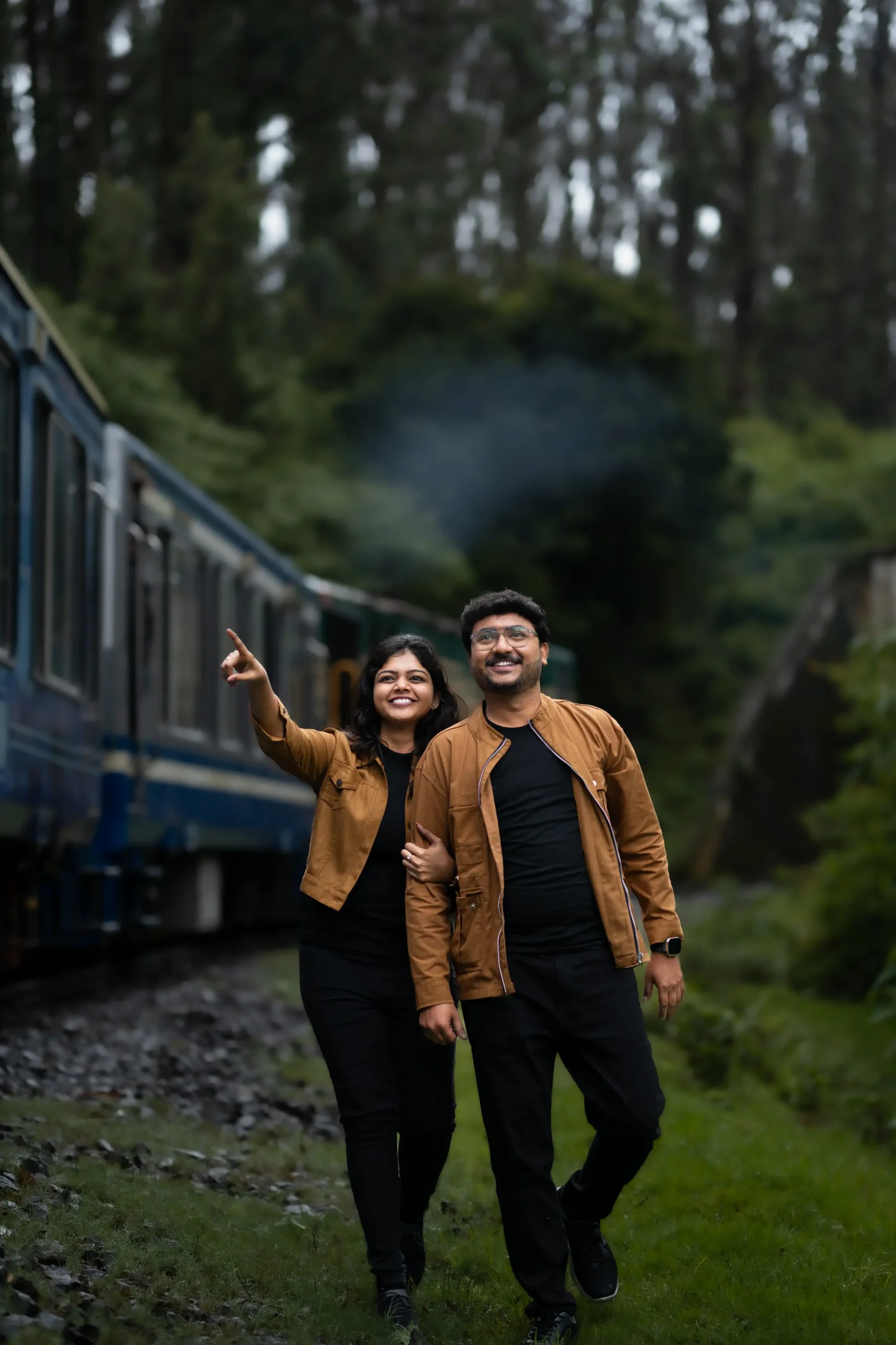 Couple enjoying outdoor photoshoot with moving train in background.🏢 Yuvi Studio Fotography & Film Making 📷 Best Outdoor Shoot Photographers 📍 Velayuthampalayam, Karur